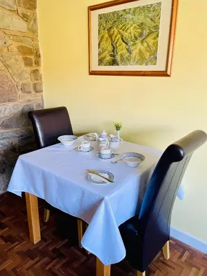 a table with a blue table cloth and two chairs at The Pantry in Erwood