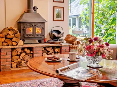 a living room with a wood stove and a table at 2 Bed in Kington oc-92986 in Lyonshall