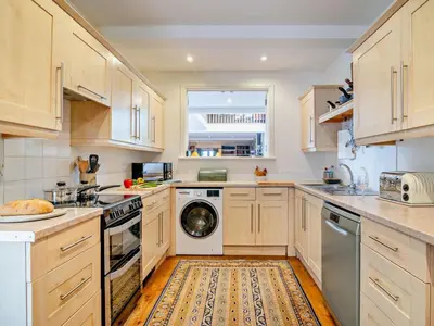 a kitchen with white cabinets and a washer and dryer at 2 Bed in Kington oc-92986 in Lyonshall