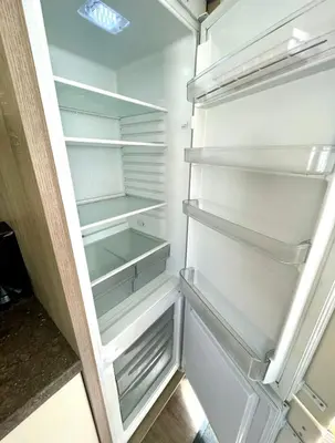 an empty refrigerator with its door open in a kitchen at Gold Standard Luxury and Modern Static Caravan at Clarach Bay in Aberystwyth