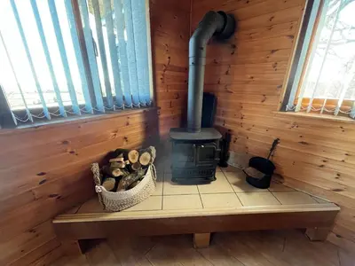 a log cabin with a wood stove in a room at Red Kite Lodge in Clyro