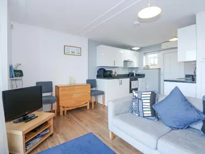 a living room with a couch and a flat screen tv at Ael Y Don in Harlech