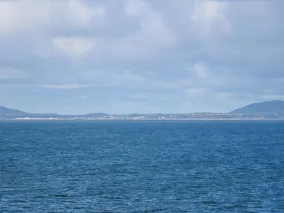 a large body of water with mountains in the background at Ael Y Don in Harlech