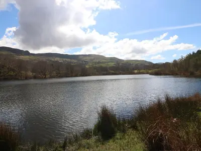 a large body of water with mountains in the background at Ael Y Don in Harlech