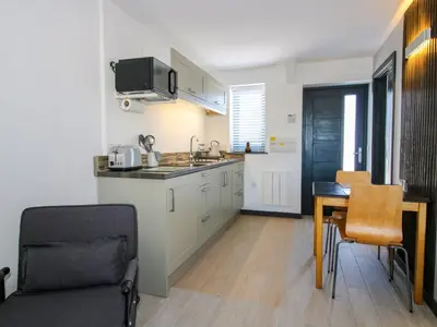 a kitchen with a sink and a table with a chair at Stiper View Barn 1 in Shrewsbury