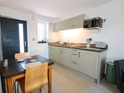 a kitchen with white cabinets and a wooden table at Stiper View Barn 2 in Shrewsbury
