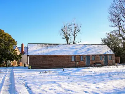 a building with a snow covered roof in a yard at Stiper View Barn 2 in Shrewsbury