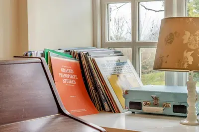 a pile of books sitting on a table next to a lamp at 6 Bed in Llanfilo oc-e30630 in Llandefalle