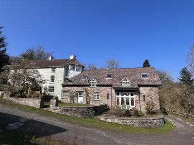 a large white house with a stone wall at 6 Bed in Llanfilo oc-e30630 in Llandefalle