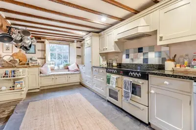 a large kitchen with white cabinets and appliances at 6 Bed in Llanfilo oc-e30630 in Llandefalle