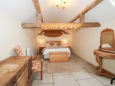a bedroom with a bed and a desk in a room at Millstone Cottages - Millstone Cottage in Shrewsbury