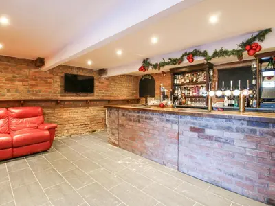 a bar with a red leather chair in a room at Millstone Cottages - Millstone Cottage in Shrewsbury