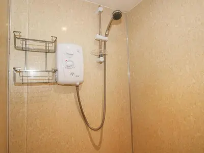 a shower with a shower head in a bathroom at Millstone Cottages - Millstone Cottage in Shrewsbury