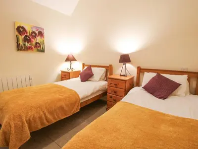 two beds in a room with two lamps on the sides at Millstone Cottages - Granary Cottage in Shrewsbury
