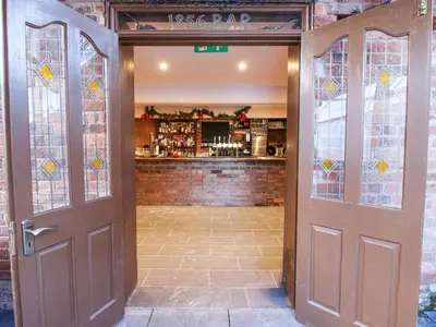 an open door with a bar in the background at Millstone Cottages - Breidden View in Shrewsbury