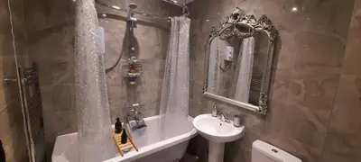 a bathroom with a sink and a bath tub next to a white sink at Conkers Cottage in Forden