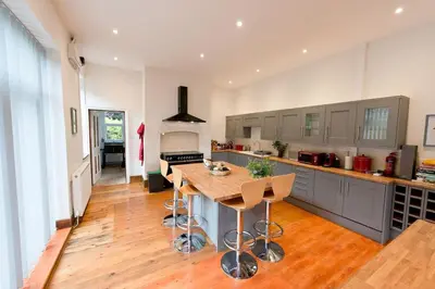 a large kitchen with a wooden table in the middle at The Old Vicarage with hot-tub & sauna in Vowchurch