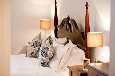 a bedroom with a bed with pillows on it at The Old Vicarage with hot-tub & sauna in Vowchurch