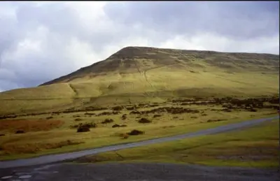 a hill with a road in the middle of a field at The Old Vicarage with hot-tub & sauna in Vowchurch