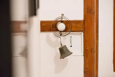 a bell hanging on a wall with a door at The Old Vicarage with hot-tub & sauna in Vowchurch