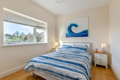 a white bedroom with a bed and a window at 2 Bed in Aberdovey oc-n30627 in Aberdyfi