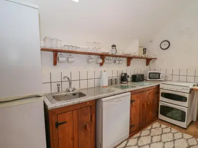 a kitchen with a sink and a stove at Y Beudy in Llanybydder