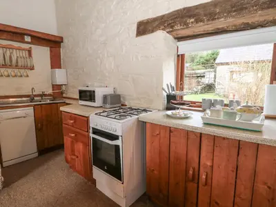 a kitchen with a stove and a microwave at Ty Tarw in Llanybydder