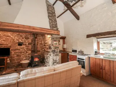 a living room with a couch and a stone fireplace at Ty Tarw in Llanybydder