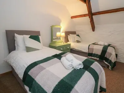 two beds in a room with towels on them at Ty Ceffylau in Llanybydder