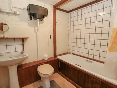 a bathroom with a tub and a toilet and a sink at Ty Ceffylau in Llanybydder