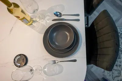 a table with a plate and wine glasses on it at Barmouth High Street Family Apartment in Barmouth