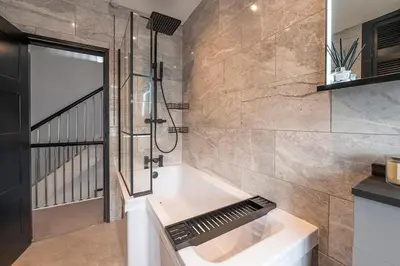 a bathroom with a bath tub and a shower at Barmouth High Street Family Apartment in Barmouth