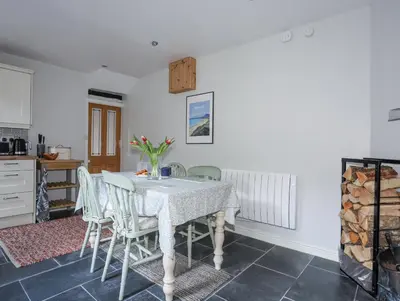 a kitchen and dining room with a table and chairs at Gwelfor in Harlech