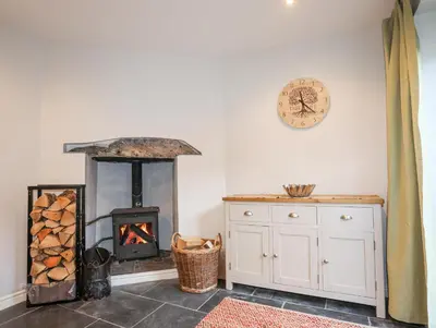 a room with a fireplace and a clock on the wall at Gwelfor in Harlech