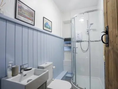 a white bathroom with a sink and a shower at Gwelfor in Harlech