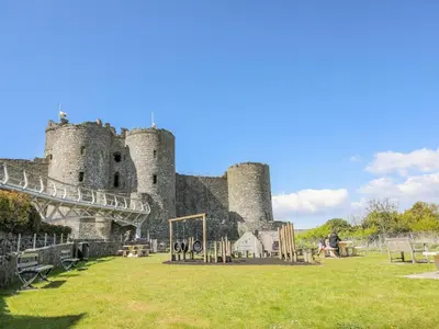 a castle with people sitting in front of it at Gwelfor in Harlech