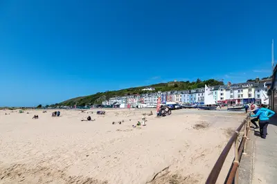 a group of people on a beach with buildings at Spacious 3 Bedroom Sea View Flat in Aberdyfi
