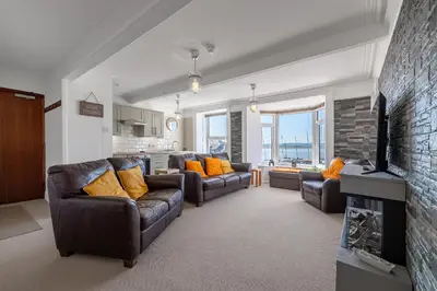 a living room with two couches and a fireplace at Spacious 3 Bedroom Sea View Flat in Aberdyfi