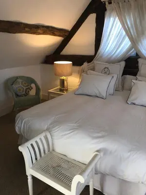 a bedroom with a white bed with a window at Logaston Common Farmhouse in Woonton