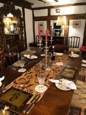 a dining room with a wooden table with a table cloth at Logaston Common Farmhouse in Woonton