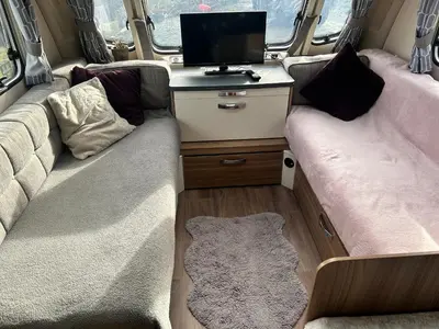 a living room with two beds and a tv in a van at Carol Anns Caravan, Working Farm Stay, Rural, Private, Fire Pit for hire, Dogs on request in Pontesbury