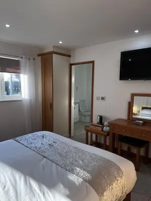 a bedroom with a bed and a desk and a television at Falconwood in Ifton Heath