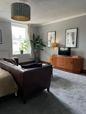 a living room with a couch and a television at Large Corris apartment with kitchen & lounge and adjoining bathroom in Dolgellau