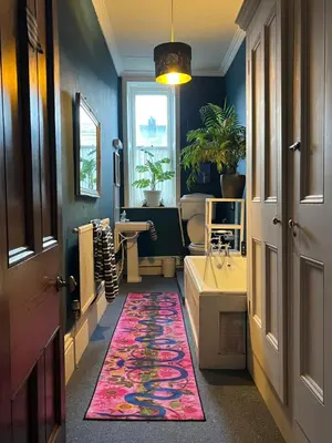 a hallway with a bathroom with a rug on the floor at Large Corris apartment with kitchen & lounge and adjoining bathroom in Dolgellau