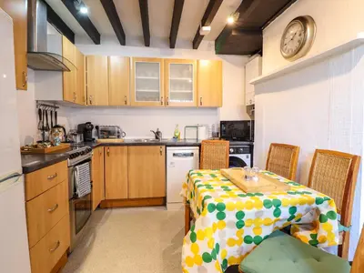 a kitchen with a table with a table cloth on it at The Courtyard Cottage in Llangollen