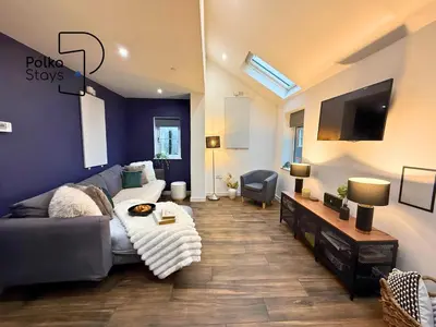 a living room with a couch and a tv at Hên Stablau - Spacious Pet-Friendly Welsh Retreat by PolkaStays in Llanfihangel-Glyn-Myfyr