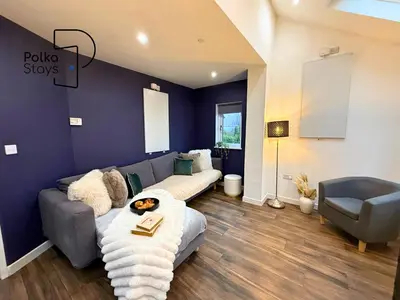 a living room with a couch and a chair at Hên Stablau - Spacious Pet-Friendly Welsh Retreat by PolkaStays in Llanfihangel-Glyn-Myfyr