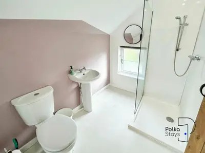 a bathroom with a toilet and a sink and a shower at Hên Stablau - Spacious Pet-Friendly Welsh Retreat by PolkaStays in Llanfihangel-Glyn-Myfyr