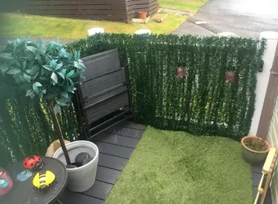 a garden with a fence and a table and a plant at 2 Bed Caravan - Sleeps 4 - Pets - Parking - Wifi in Aberystwyth