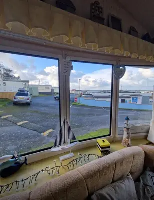 a living room window with a view of a parking lot at 2 Bed Caravan - Sleeps 4 - Pets - Parking - Wifi in Aberystwyth